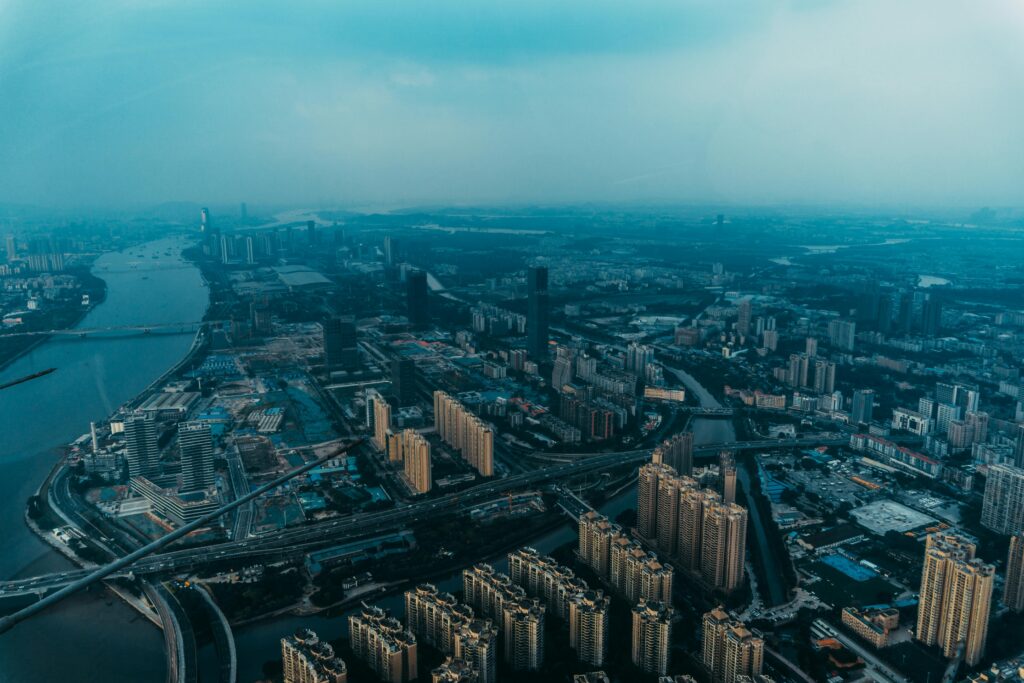 Aerial view of Guangzhou's urban landscape with skyscrapers and rivers during dusk.