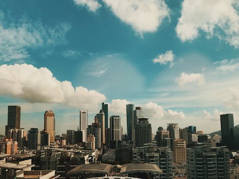 Dramatic aerial view of Nanjing's skyscrapers under a cloudy sky, highlighting urban architecture.