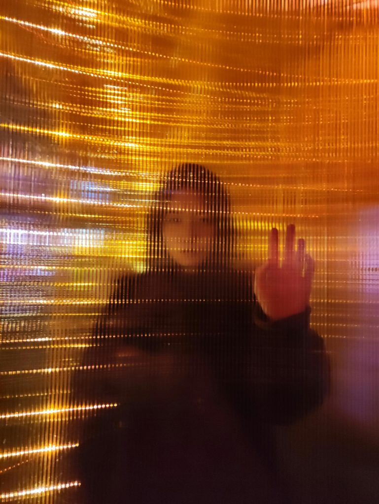 Artistic blur effect of a person behind glowing orange glass in Shanghai, China.