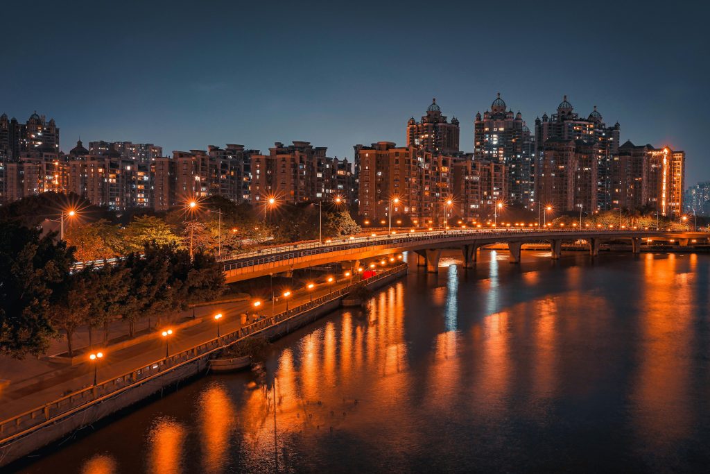 Beautiful nighttime view of Guangzhou cityscape with illuminated bridge and reflections in the river.