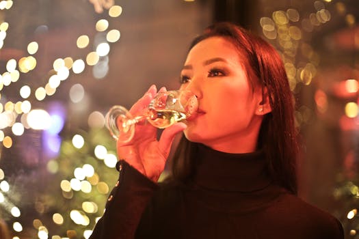 A stylish woman enjoys a glass of wine indoors with bokeh lighting, creating a warm nightlife ambiance.